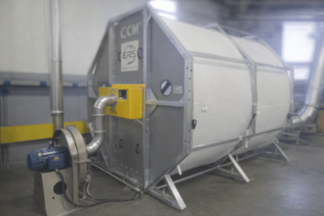 Photorealistic close-up of ERS CCM OCT filter module installed on a tissue dust collector in a converting line, showing source-capture hood and accessible filter cartridges.