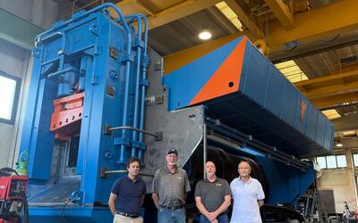 ERS team members standing with a 1,200-tonne track-mounted shear at the Taurus manufacturing facility in Daverio, Italy