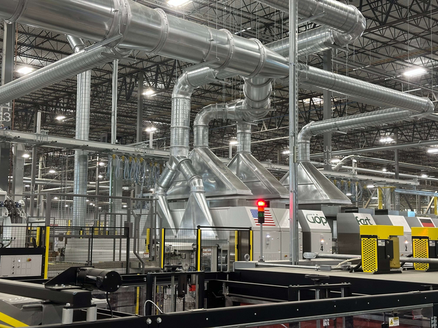 ERS dust collection hoods installed above a GOPFERT die cutter, connected to the CCM® OCT Filter system for efficient scrap and dust removal.