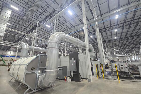 Engineered Recycling Systems CCM® OCT Filter installed in a corrugated manufacturing facility, showcasing 2025 model with modular segments, rotating anti-static suction nozzles, and positive-pressure airflow for high-efficiency dust filtration.