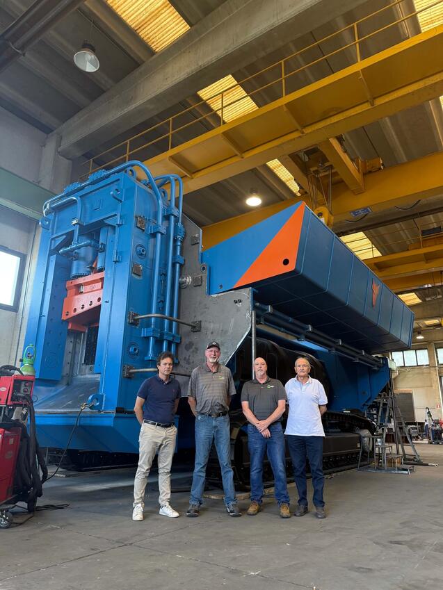 ERS team members standing with a 1,200-tonne track-mounted shear at the Taurus manufacturing facility in Daverio, Italy