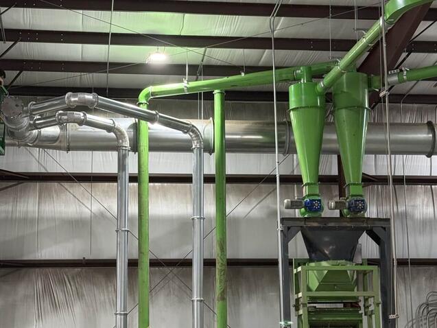 Twin cyclones with rotary airlocks discharging onto a screen, with transfer lines and fans, part of a metals separation line upgraded inside an existing plant