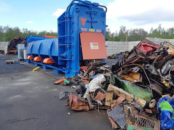 ERS HAKA entry-level shear baler processing mixed scrap metal at an outdoor recycling yard.