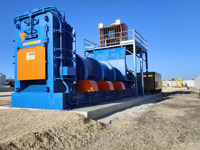 Blue TAURUS shear baler installed on a scrap yard, with the operator cabin on a raised platform behind the machine