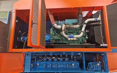 Open power unit of a TAURUS shear baler, with the engine and hydraulic pumps above and the valve panel with its pressure gauges below