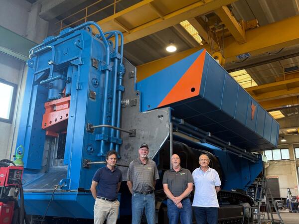 ERS team members standing with a 1,200-tonne track-mounted shear at the Taurus manufacturing facility in Daverio, Italy